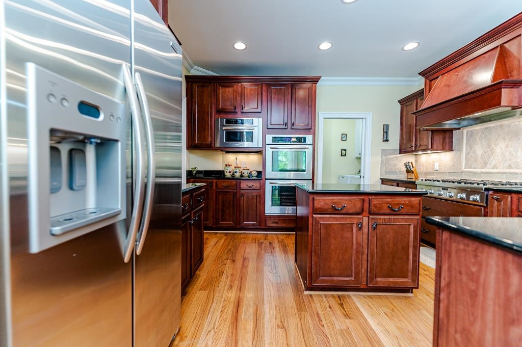 225 Henrys Ridge Road Pittsboro, NC 27312 - Photo 10 of 67 Wow! What a spectacular chef's kitchen! Custom cabinetry & range hood. Granite countertops. Spacious pantry. Island with storage. Under counter lighting. Double wall oven with convection.