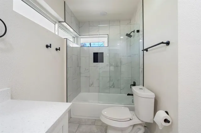 a bathroom with a granite countertop toilet sink and shower