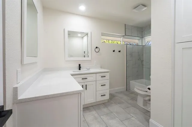 a spacious bathroom with a shower sink and mirror