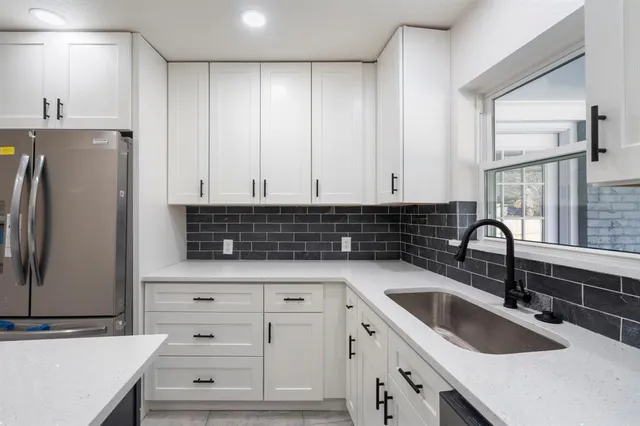 a kitchen with granite countertop a sink and a refrigerator