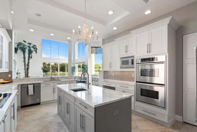 a kitchen with kitchen island granite countertop a sink stainless steel appliances and cabinets