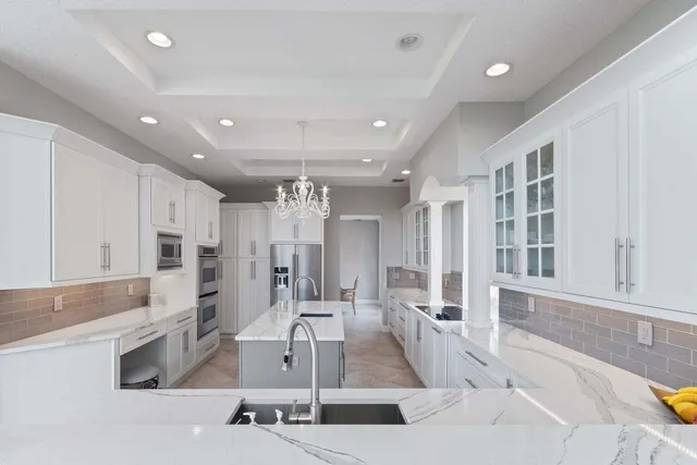 a large kitchen with stainless steel appliances a large counter top a stove and a refrigerator