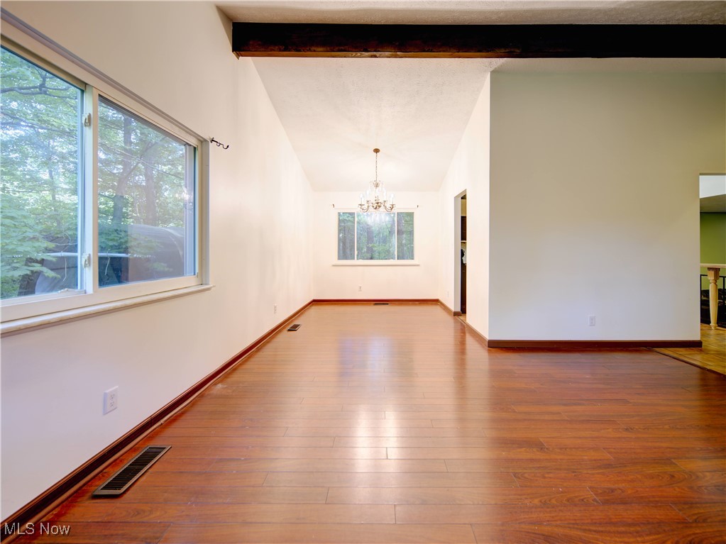 8075 Mulberry Road Chesterland, OH 44026 - Photo 8 of 38 Empty room featuring wood-type flooring and a chandelier