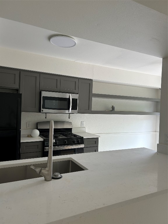 5903 Cougar Drive, Unit B Austin, TX 78745 - Photo 13 of 16 a kitchen with white cabinets and stainless steel appliances