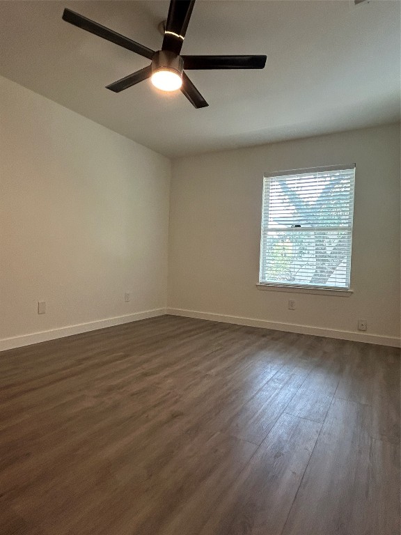 5903 Cougar Drive, Unit B Austin, TX 78745 - Photo 7 of 16 an empty room with wooden floor chandelier fan and windows