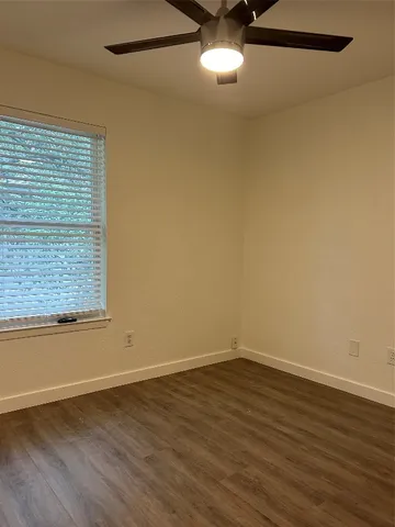 a view of a room with wooden floor and window