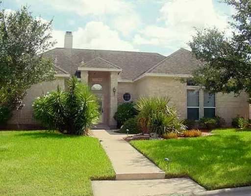 a front view of a house with a garden and plants