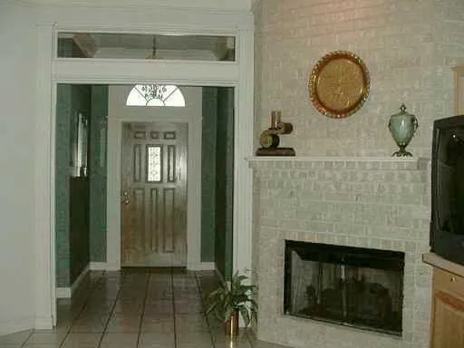 a view of a livingroom with wooden floor and a fireplace