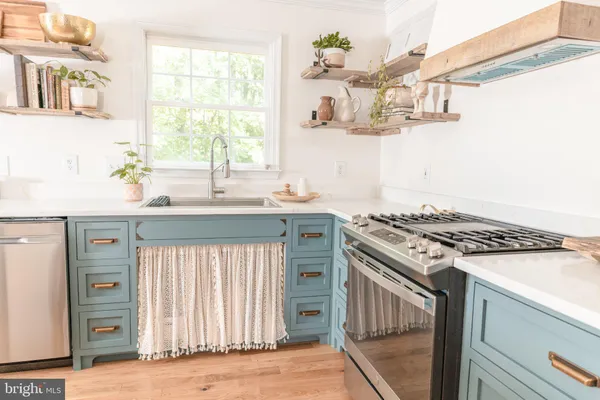 a kitchen with a stove a sink and a window