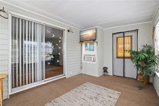 a view of a hallway to a livingroom with furniture and windows