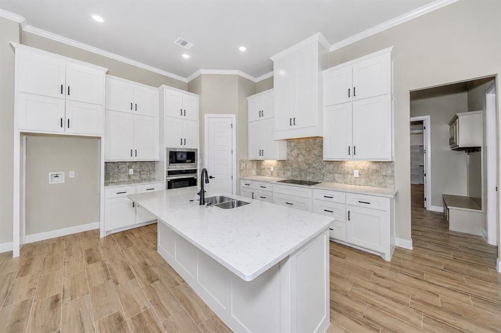 1057 Vh Ranch Poolville, TX 76487 - Photo 11 of 38 a kitchen with white cabinets and stainless steel appliances
