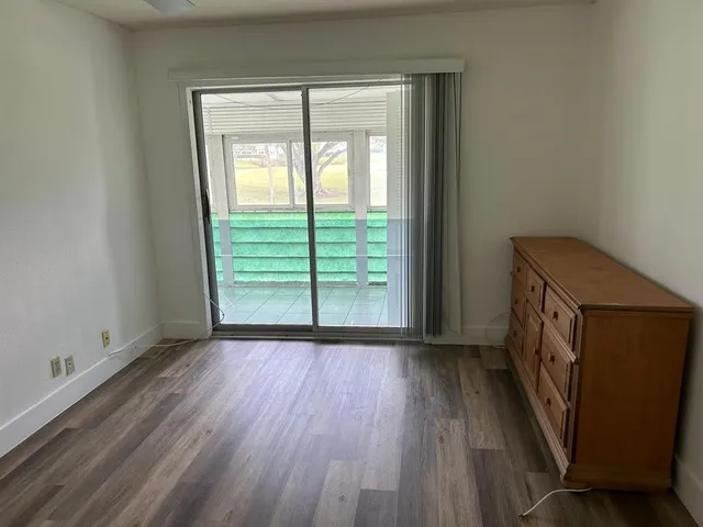 a view of a room that has wooden floor and a window