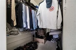 a view of walk in closet with clothes