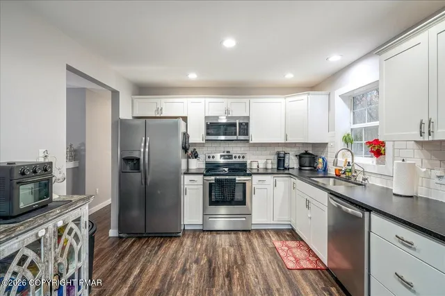 a kitchen with kitchen island granite countertop stainless steel appliances cabinets a sink and a center island
