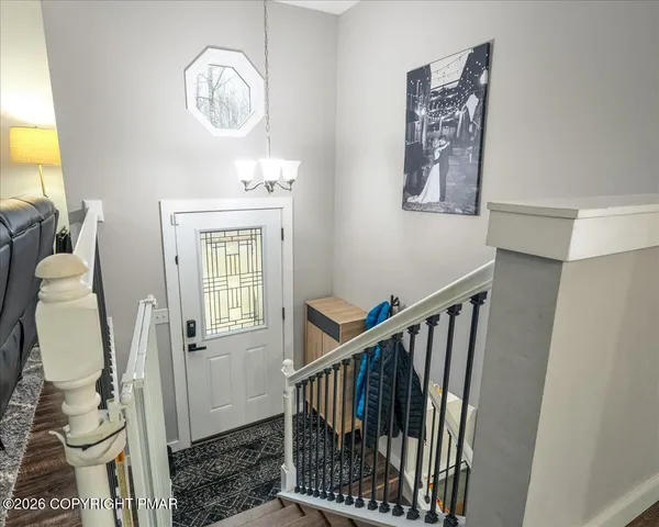 a view of a hallway with windows and chandelier