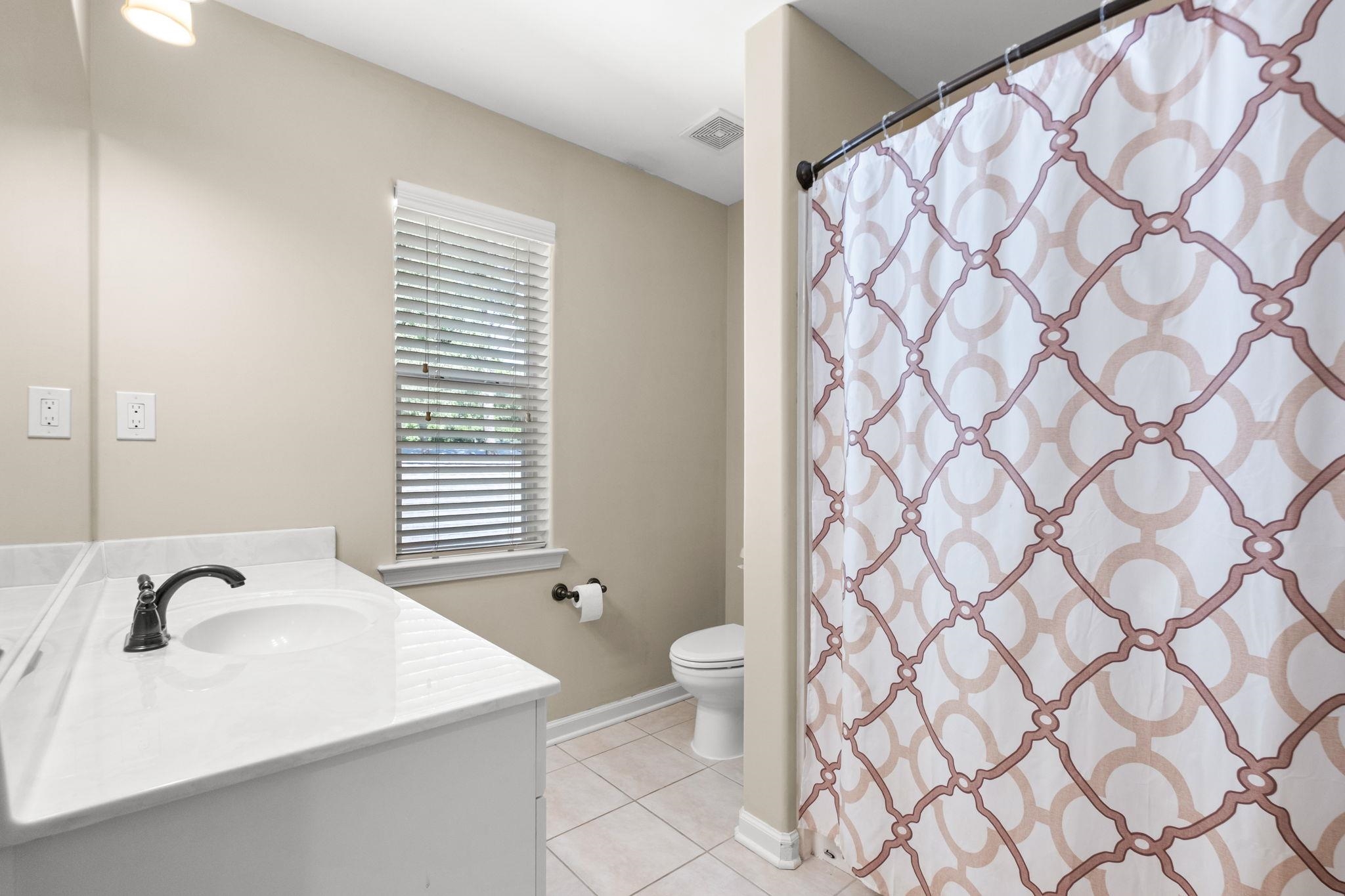 2275 McVay Road, Unit 2275 Germantown, TN 38138 - Photo 23 of 40 a bathroom with a sink a toilet and shower curtain