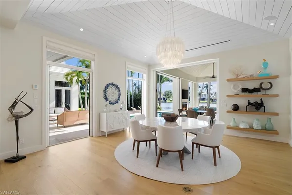 a living room with furniture a chandelier and a dining table