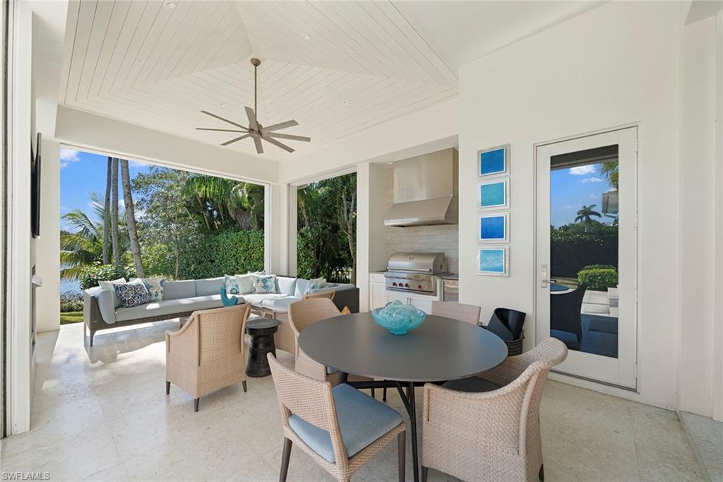 575 Palm Circle East Naples, FL 34102 - Photo 14 of 49 a dining room with furniture a chandelier and wooden floor