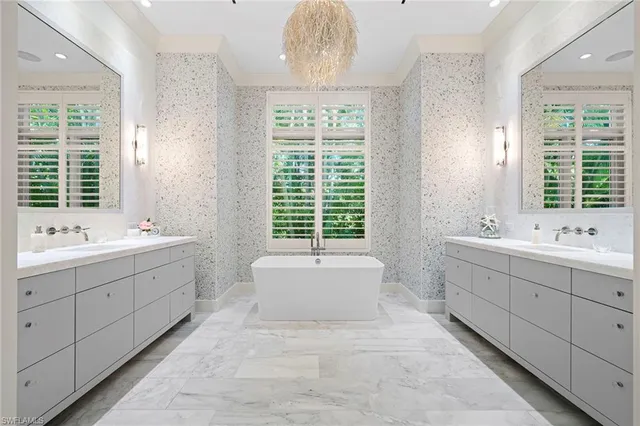 a bathroom with a double vanity sink bathtub and next to a window