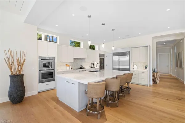 a kitchen with stainless steel appliances a dining table chairs and granite counter tops