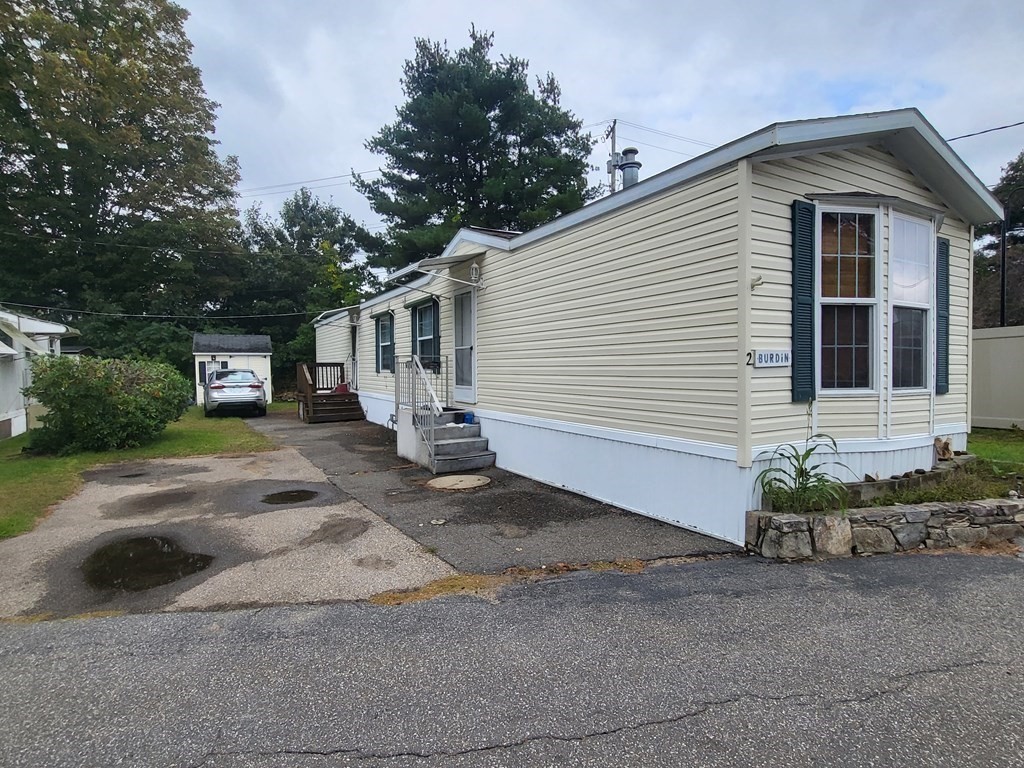 365 Main Street, Unit 2 Sturbridge, MA 01566 - Photo 2 of 24 a front view of a house with a yard and garage