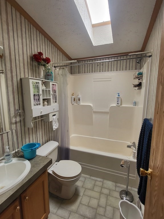 365 Main Street, Unit 2 Sturbridge, MA 01566 - Photo 22 of 24 a bathroom with a granite countertop bathtub shower sink vanity and toilet