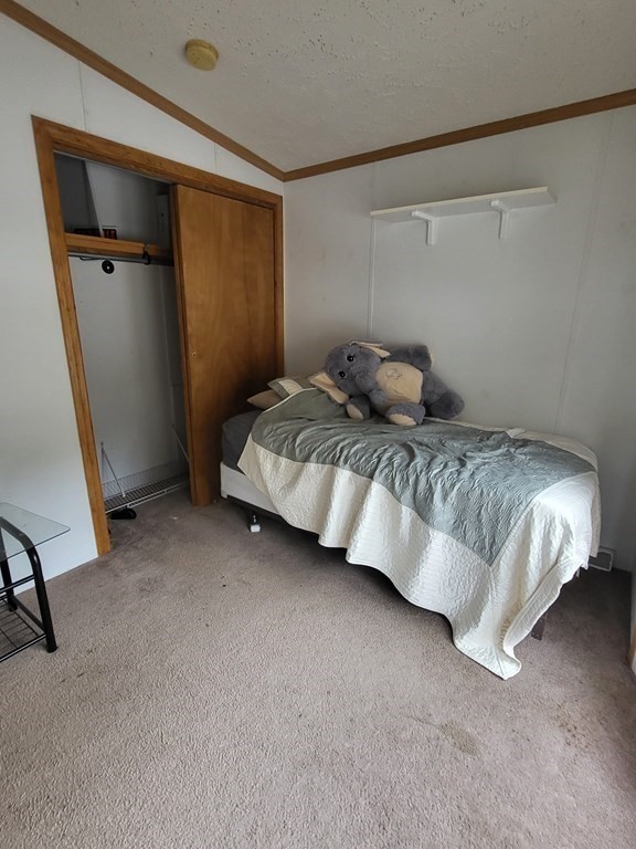 365 Main Street, Unit 2 Sturbridge, MA 01566 - Photo 23 of 24 a bedroom with a bed and a mirror