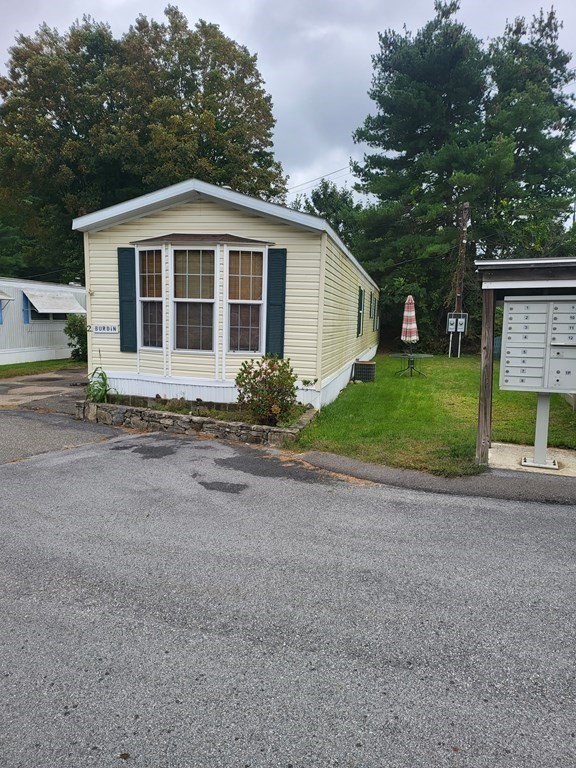 365 Main Street, Unit 2 Sturbridge, MA 01566 - Photo 3 of 24 a front view of a house with a yard and a garage