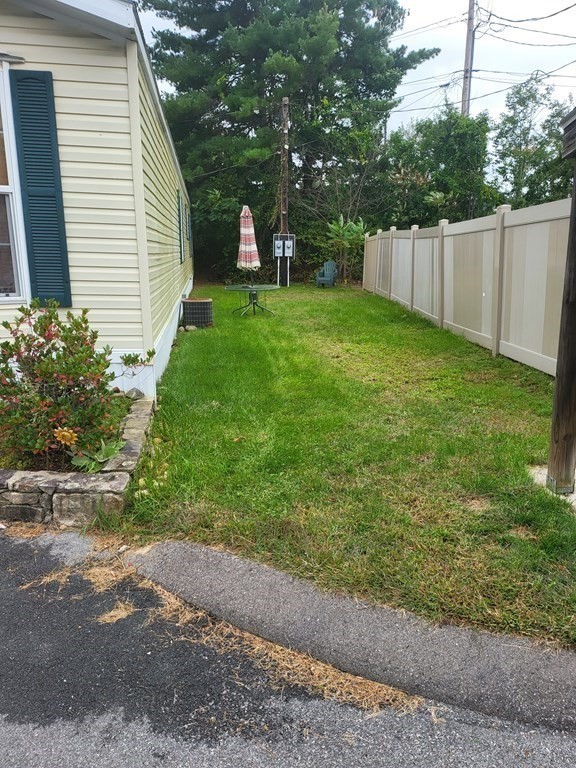 365 Main Street, Unit 2 Sturbridge, MA 01566 - Photo 4 of 24 a view of a backyard with large trees and wooden fence