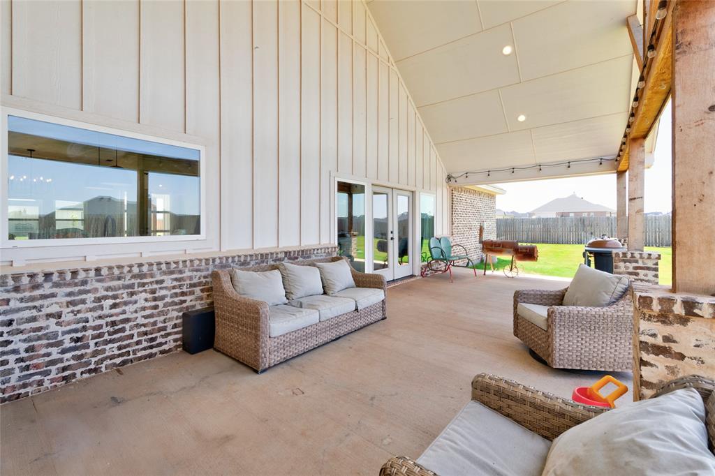 120 Long Ranger Road Abilene, TX 79602 - Photo 21 of 23 Expansive covered patio featuring a vaulted ceiling with recessed lighting, board and batten siding, brick wainscoting, and concrete flooring
