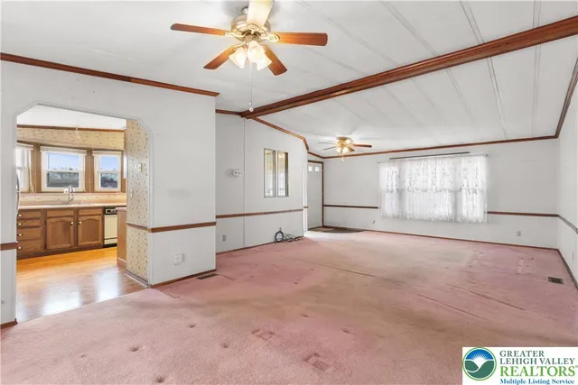 a spacious bedroom with a bed a couch and a large window