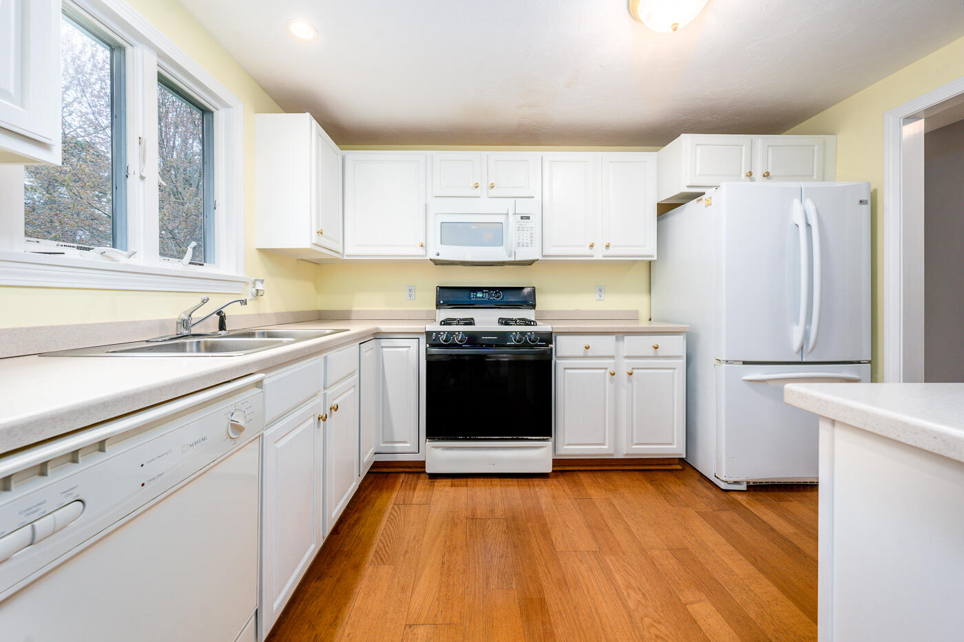 9 Executive Drive Mashpee, MA 02649 - Photo 9 of 15 a kitchen with a white cabinets and wooden floor