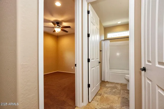 an empty room with a window and a ceiling fan