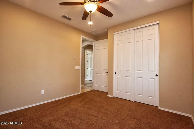 a view of a hallway with wooden floor and a bathroom
