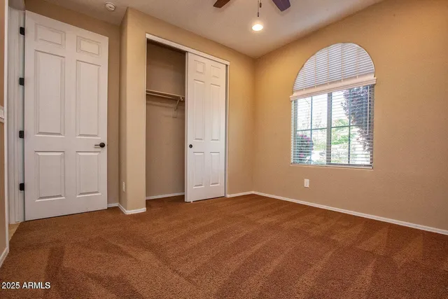 a view of a livingroom with a ceiling fan and window