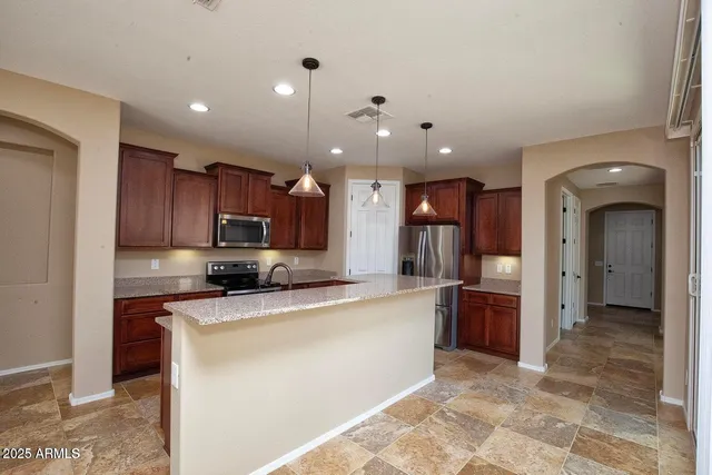a large kitchen with cabinets and stainless steel appliances