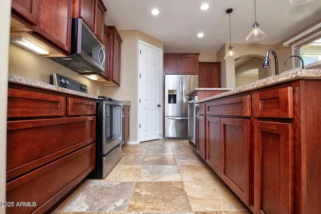 a view of an empty room with windows & wooden door