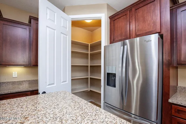 a view of a kitchen with a sink and dishwasher a refrigerator with wooden cabinets