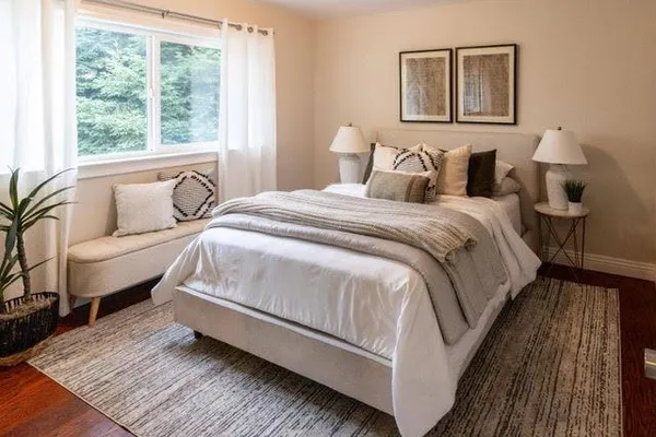 a spacious bedroom with a bed and wooden floor