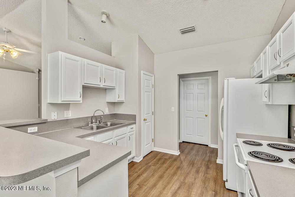 1399 Guardian Drive Jacksonville, FL 32221 - Photo 13 of 29 a kitchen that has a sink a stove and a wooden floor