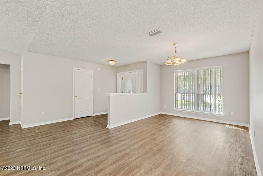 1399 Guardian Drive Jacksonville, FL 32221 - Photo 6 of 29 a view of an empty room with wooden floor and a window