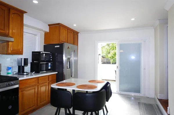 a kitchen with a table chairs refrigerator and microwave
