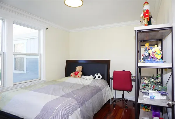 a bedroom with a bed a couch and a potted plant