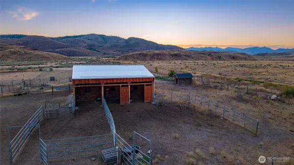 a view of a house with a mountain yard and a car parked