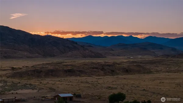 a view of a lake with sunset in background