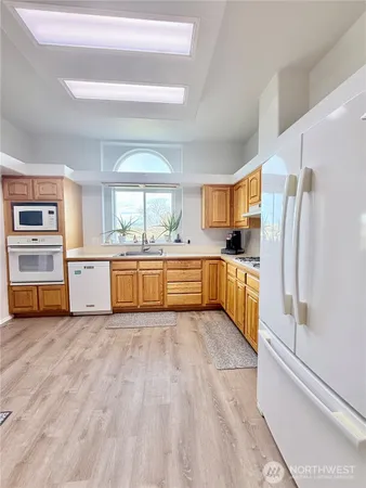 a large kitchen with stainless steel appliances a stove a sink and a refrigerator