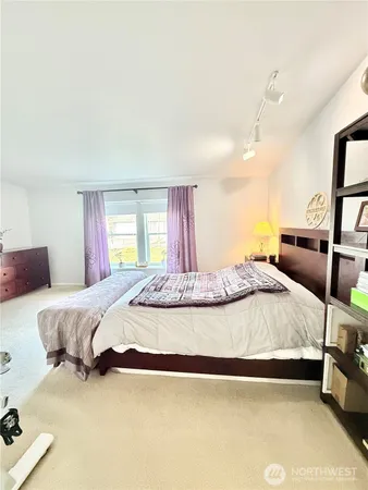 a spacious bedroom with a bed and dresser