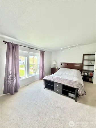 a spacious bedroom with a bed and a cabinets
