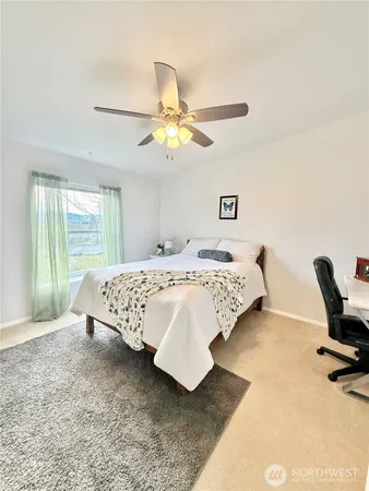 a bedroom with a bed a couch and a chandelier