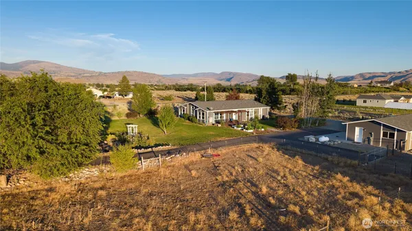 an aerial view of residential houses with outdoor space and trees